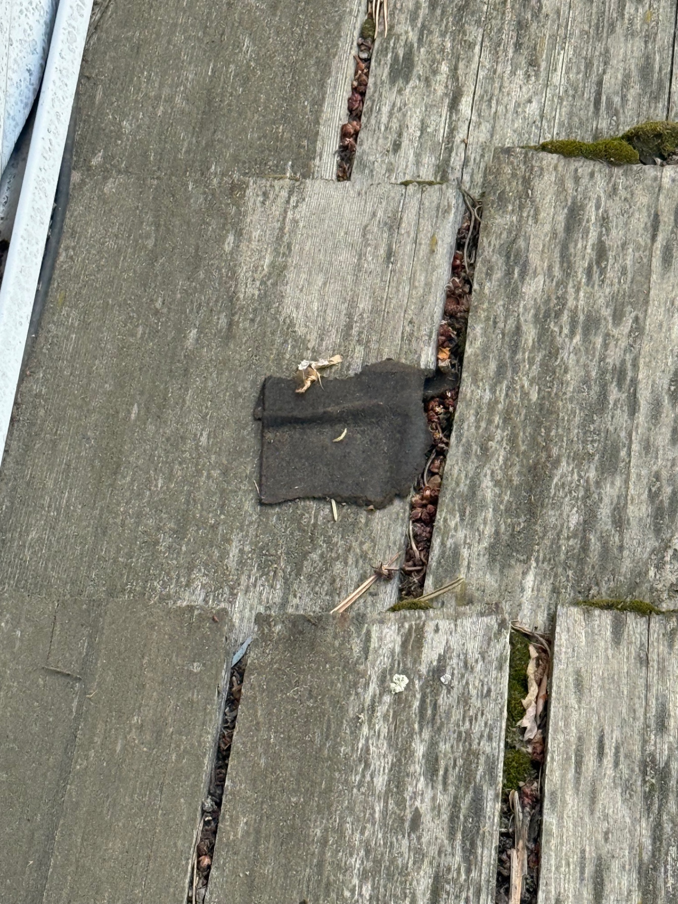 Close-up of underlayment patch beneath cedar shakes